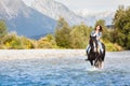 Smiling Female horse rider crossing river