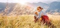 Smiling female hugs her beagle dog resting as they walking in mountains together