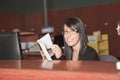 Smiling female librarian holding a book standing Royalty Free Stock Photo