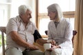 Smiling female nurse measure blood pressure of senior male patient Royalty Free Stock Photo