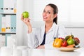 Female nutritionist holding a green apple