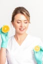 Smiling female nutritionist holding a sliced orange, looking at camera over white background, healthy diet concept. Royalty Free Stock Photo