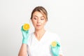 Smiling female nutritionist holding a sliced orange, looking at camera over white background, healthy diet concept. Royalty Free Stock Photo