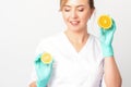 Smiling female nutritionist holding a sliced orange, looking at camera over white background, healthy diet concept. Royalty Free Stock Photo