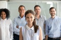 Smiling female office worker looking at camera with diverse team Royalty Free Stock Photo