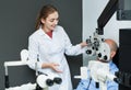 Smiling female optician doing eye examination with lamp