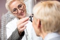 Smiling female optometrist examining mature woman, determining diopter in ophthalmology clinic Royalty Free Stock Photo