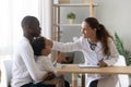 Smiling female pediatrician stroking head of cute small preschool patient. Royalty Free Stock Photo