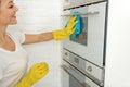 Smiling female person cleaning stove Royalty Free Stock Photo