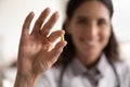 Smiling female pharmacist looking at camera presenting new effective pill Royalty Free Stock Photo