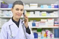 Smiling female Pharmacist Talking to Someone on Phone on pharmacy background
