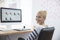 Smiling female photo editor sitting at the table