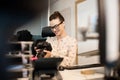 Smiling female photographer using camera at creative office Royalty Free Stock Photo