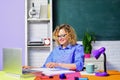 Smiling female school teacher or university professor working with laptop in classroom. Young student girl in glasses Royalty Free Stock Photo