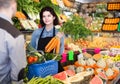 Female shopping assistant helping customer to buy fruit and vegetables in grocery shop Royalty Free Stock Photo