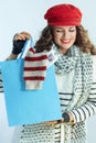 Smiling female showing blue shopping bag with purchased sweater Royalty Free Stock Photo