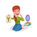 Smiling female speech therapist sitting on the floor showing letter Y, teacher working with children at kindergarten Royalty Free Stock Photo