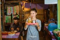 smiling female stall waitress serving traditional drinks using a tray