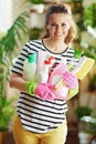 Smiling female in striped shirt in sunny day housecleaning