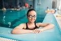 Smiling female swimmer in goggles swims in pool Royalty Free Stock Photo
