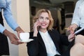 Assistant offering coffee to her female boss at office