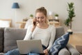 Smiling female talking on smartphone browsing internet from home Royalty Free Stock Photo