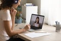 Smiling female teacher talk on video call with little child