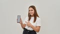 Smiling female teenage showing smartphone on white