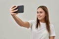Smiling female teenage taking selfie on smartphone