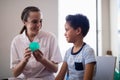 Smiling female therapist showing stress ball to boy Royalty Free Stock Photo