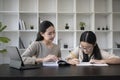 Female tutor helping young student doing homework. Tutorial and educational concept. Royalty Free Stock Photo