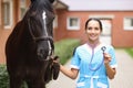 Smiling female veterinarian doctor holding stethoscope next to horse Royalty Free Stock Photo