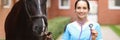 Smiling female veterinarian doctor holding stethoscope next to horse Royalty Free Stock Photo