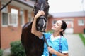 Smiling female veterinarian stroking black horse closeup Royalty Free Stock Photo