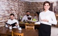 Smiling female waiter bringing order for visitors Royalty Free Stock Photo