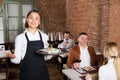 Smiling female waiter showing country restaurant Royalty Free Stock Photo