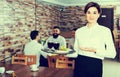 Smiling female waitress bringing order for guest Royalty Free Stock Photo