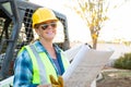 Smiling Female Worker Holding Technical Blueprints