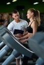 Smiling female working with personal coach in gym Royalty Free Stock Photo