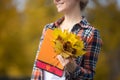 Smiling female young student outdoors holding yellow leaves Royalty Free Stock Photo