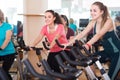 Smiling females of different age training on exercise bikes Royalty Free Stock Photo