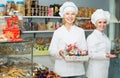 Smiling females staff offering sweets Royalty Free Stock Photo