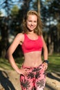 smiling fit athletic woman standing in a forest, sweating and taking a break from intense workout Royalty Free Stock Photo