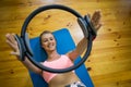 Smiling fit woman exercising with pilates ring on mat Royalty Free Stock Photo