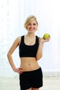 Smiling fit woman holding green apple Royalty Free Stock Photo