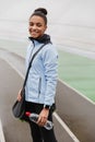 Smiling fit young african sportswoman carrying sportsbag