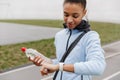 Smiling fit young african sportswoman carrying sportsbag