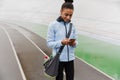 Smiling fit young african sportswoman carrying sportsbag