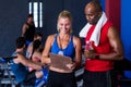 Smiling fitness instructor discussing with man in gym Royalty Free Stock Photo
