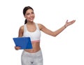 Smiling fitness woman holding clipboard and presenting to side